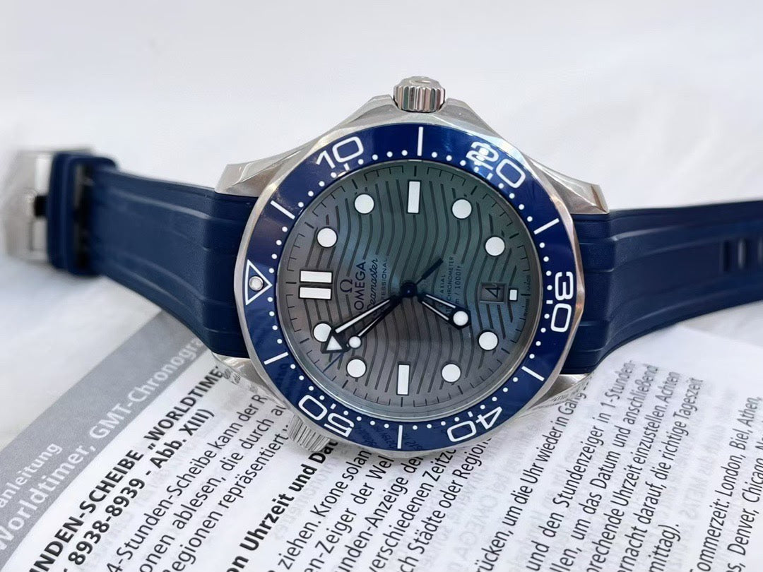 Omega Wristwatch with blue strap and dark face on an open book