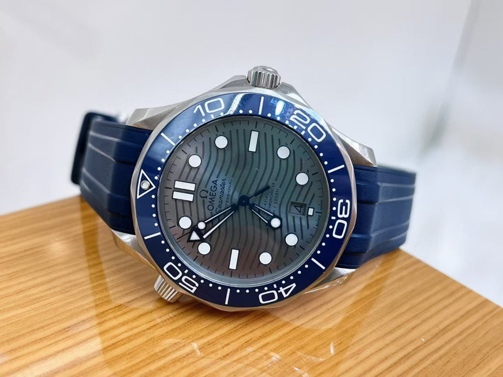 Blue and silver Omega watch on a wooden surface with a white background