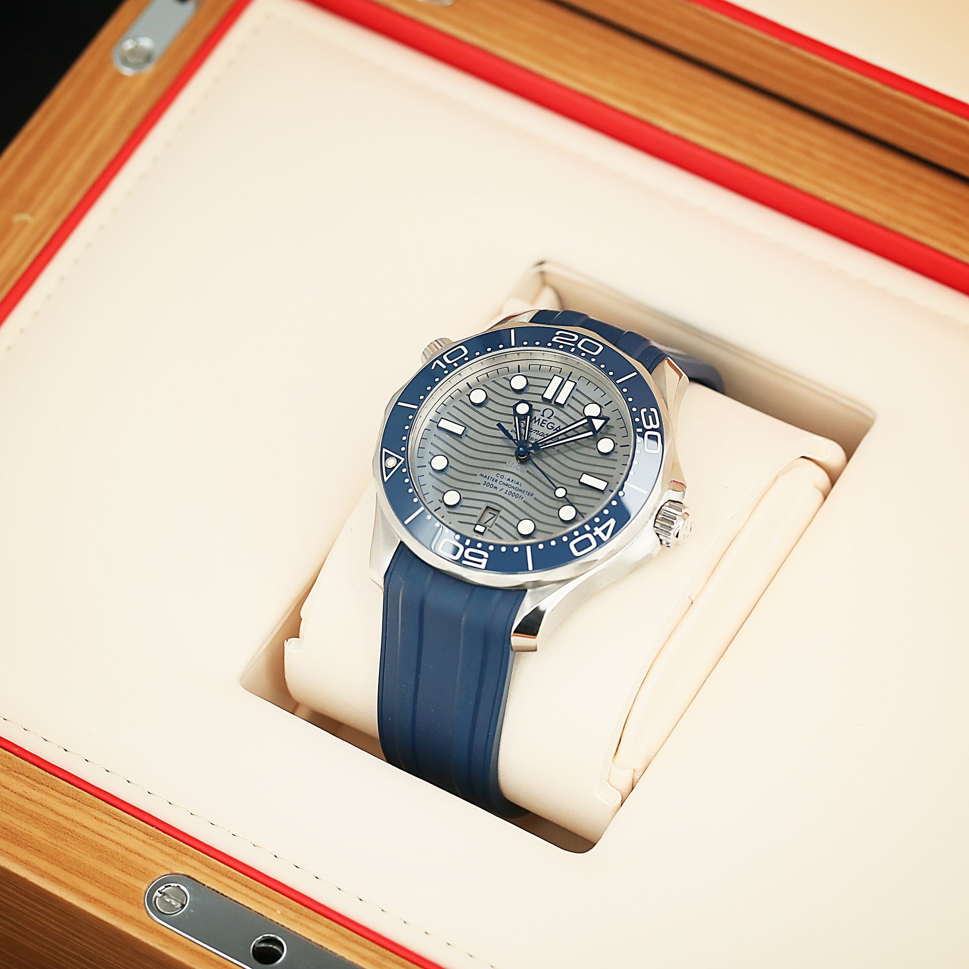 Blue Omega wristwatch with a detailed face in a wooden and leather box